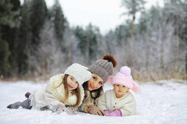 Famiglia felice che gioca e ride in inverno all'aperto nella neve. Giornata invernale del parco cittadino.