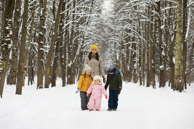 Famiglia felice che gioca e ride in inverno all'aperto nella neve. Giornata invernale del parco cittadino.
