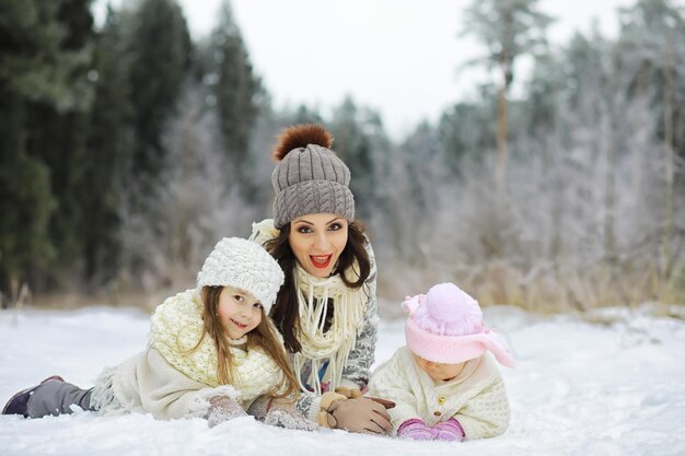 Famiglia felice che gioca e ride in inverno all'aperto nella neve. Giornata invernale del parco cittadino.