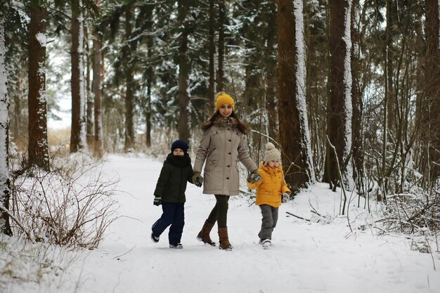 Famiglia felice che gioca e ride in inverno all'aperto nella neve. Giornata invernale del parco cittadino.