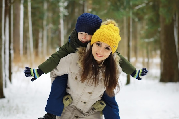 Famiglia felice che gioca e ride in inverno all'aperto nella neve. Giornata invernale del parco cittadino.