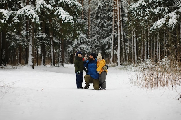 Famiglia felice che gioca e ride in inverno all'aperto nella neve. Giornata invernale del parco cittadino.