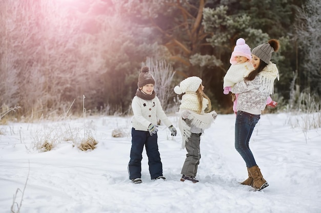 Famiglia felice che gioca e ride in inverno all'aperto nella neve. Giornata invernale del parco cittadino.