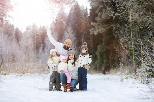 Famiglia felice che gioca e ride in inverno all'aperto nella neve. Giornata invernale del parco cittadino.