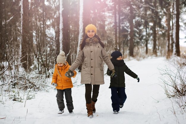 Famiglia felice che gioca e ride in inverno all'aperto nella neve. Giornata invernale del parco cittadino.