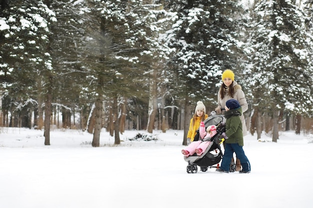 Famiglia felice che gioca e ride in inverno all'aperto nella neve Giornata invernale del parco cittadino