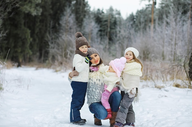 Famiglia felice che gioca e ride in inverno all'aperto nella neve Giornata invernale del parco cittadino