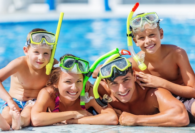 Famiglia felice che gioca in piscina. Concetto di vacanza estiva