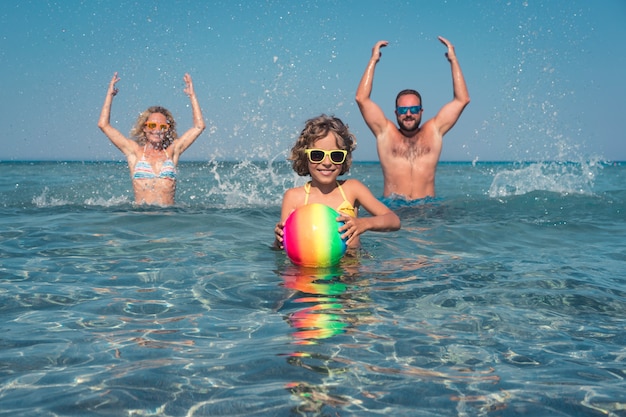 Famiglia felice che gioca nel mare Madre e padre del bambino che si divertono durante le vacanze estive Concetto di stile di vita sano e attivo