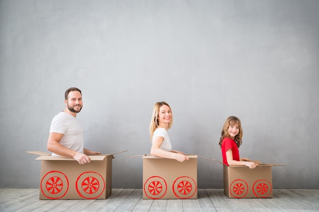 famiglia felice che gioca nella nuova casa padre madre e figlio che si divertono insieme giorno del trasloco