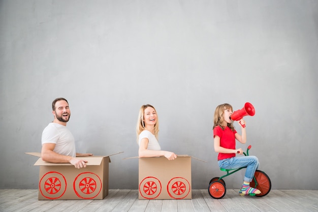 famiglia felice che gioca nella nuova casa padre madre e figlio che si divertono insieme giorno del trasloco