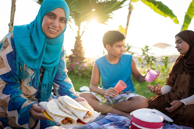 Famiglia felice che gode del picnic sulla spiaggia vicino al mare