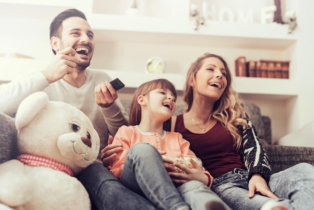 Famiglia felice che guarda la TV insieme a casa