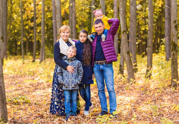 Famiglia felice che ha divertimento all'aperto nella sosta di autunno