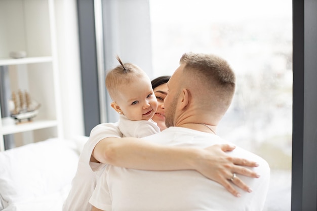 Famiglia felice che ha tempo libero a letto a casa