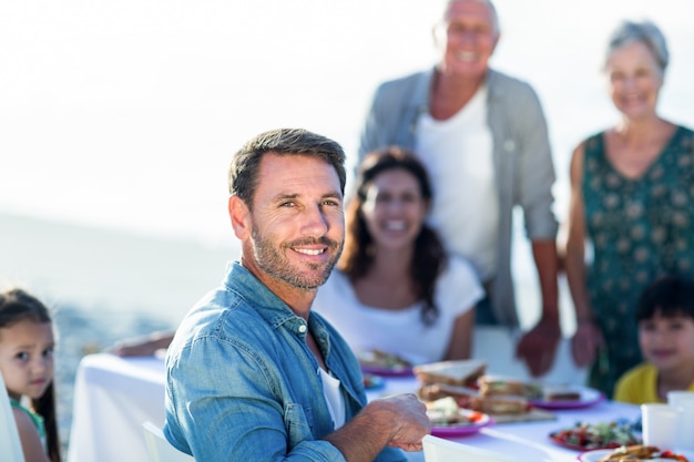 Famiglia felice che ha un picnic in spiaggia