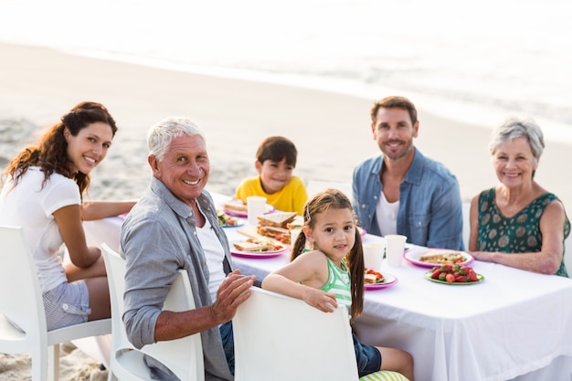 Famiglia felice che ha un picnic in spiaggia