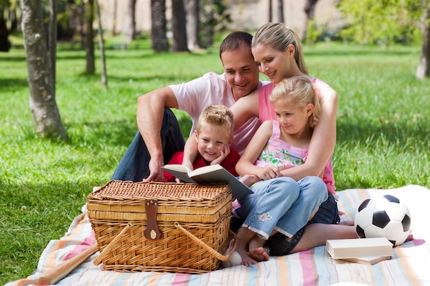 Famiglia felice che legge in un parco