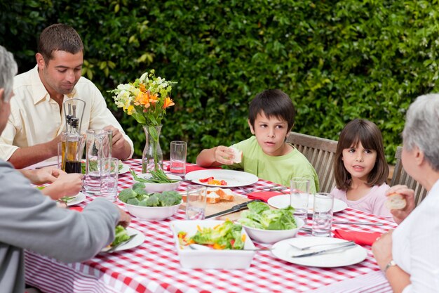 Famiglia felice che mangia nel giardino