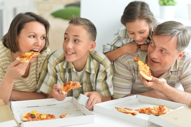 Famiglia felice che mangia pizza insieme nella sosta di autunno