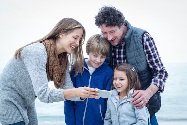 Famiglia felice che osserva in cellulare