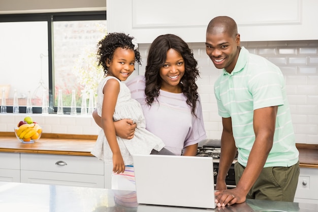 Famiglia felice che per mezzo del computer portatile