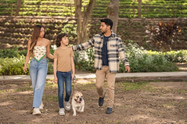Famiglia felice che porta a spasso il cane in un parco