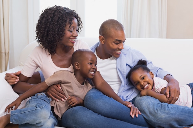 Famiglia felice che posa insieme sullo strato