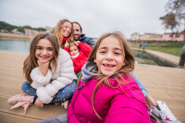 Famiglia felice che prende insieme un selfie all'aperto