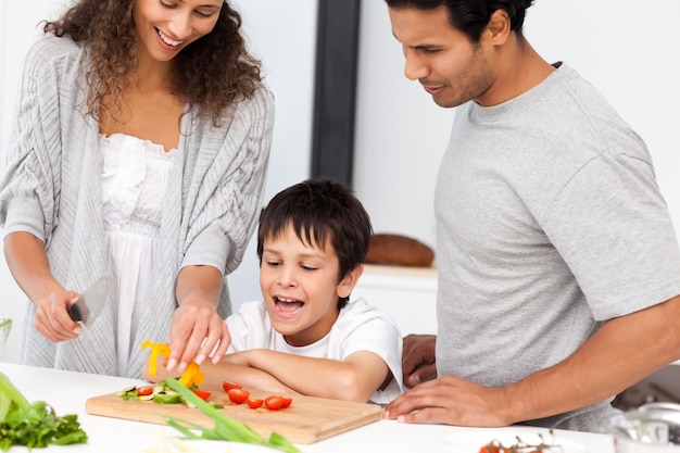 Famiglia felice che prepara insieme un&#39;insalata nella cucina