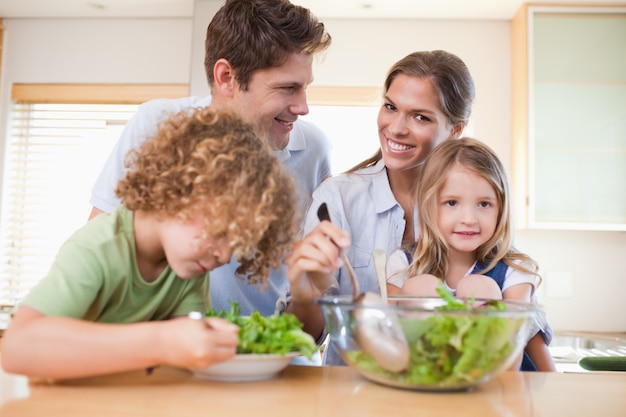 Famiglia felice che prepara un&#39;insalata