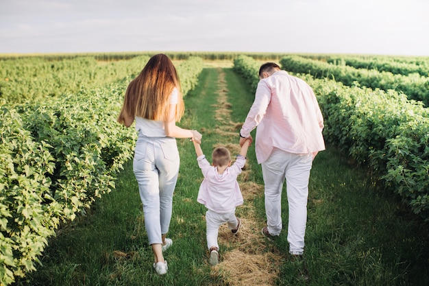 Famiglia felice che propone su un campo verde