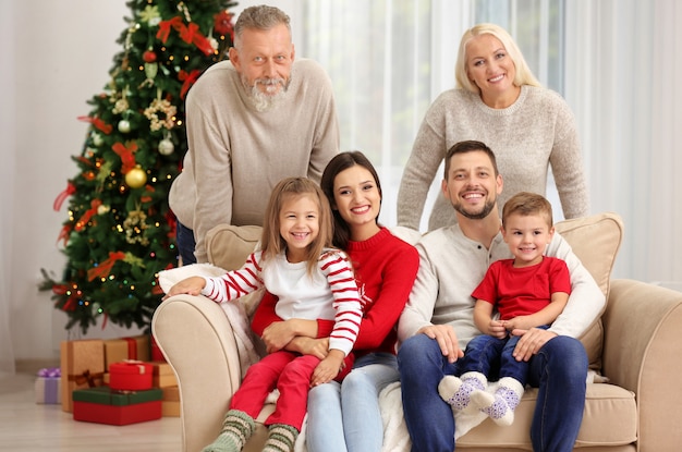 Famiglia felice che riposa nella stanza decorata per Natale