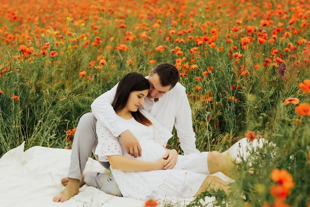 Famiglia felice che riposa sul campo di papaveri