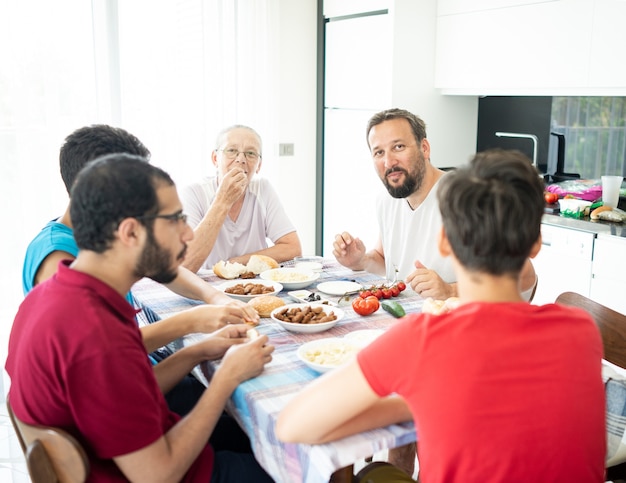 Famiglia felice che si diverte a mangiare cibo nella sala da pranzo