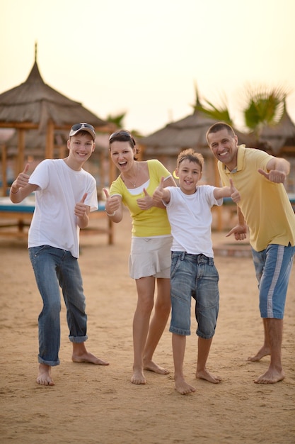 Famiglia felice che si diverte al resort di vacanza vicino alle palme