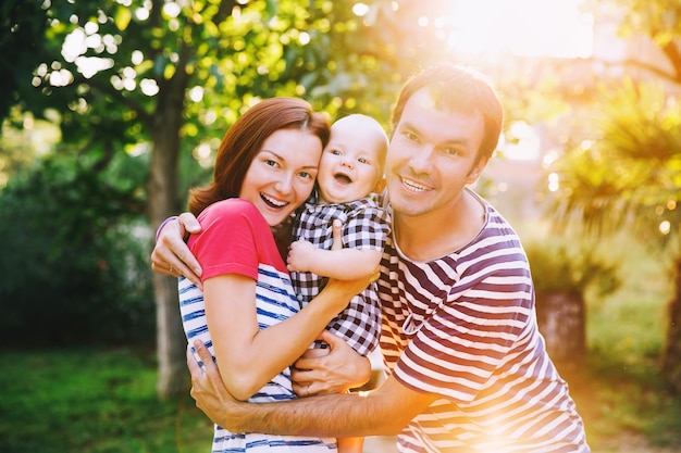 Famiglia felice che si diverte e ride in una giornata primaverile estiva al tramonto