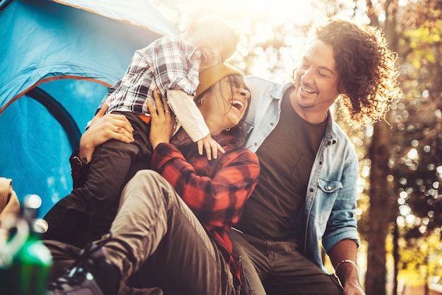 Famiglia felice che si diverte in campeggio nella foresta