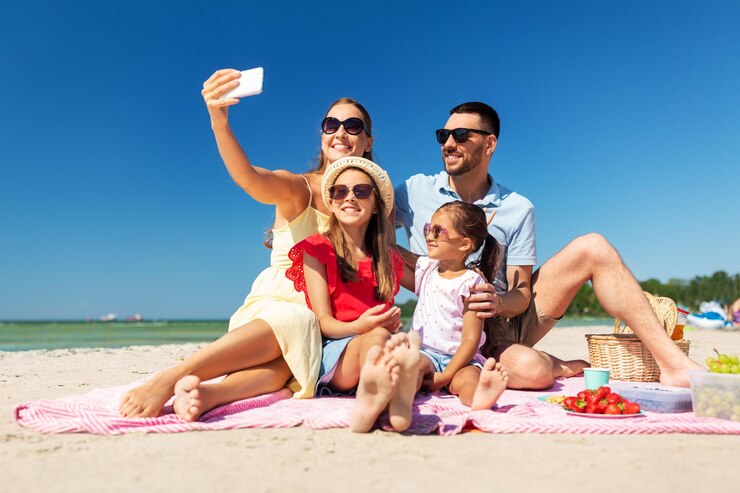 Foto famiglia felice che si fa un selfie sulla spiaggia estiva