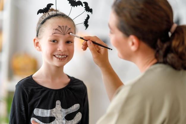 Famiglia felice che si prepara per Halloween Madre e figlio in costume di carnevale a casa