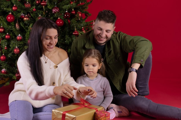 Famiglia felice che si siede accanto a un albero di Natale