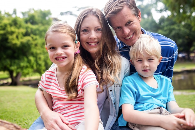 Famiglia felice che si siede insieme nel parco