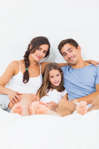 Famiglia felice che si siede sul letto