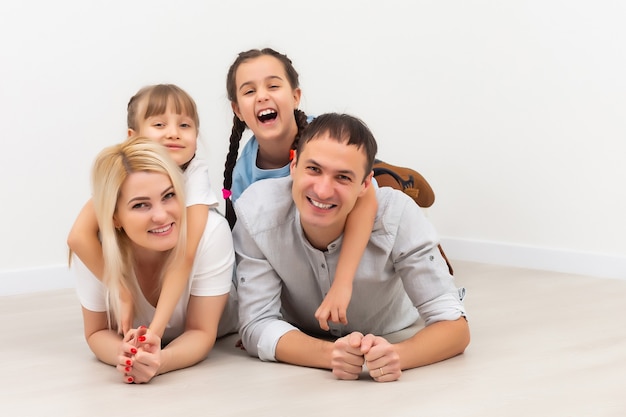 Famiglia felice che si siede sul pavimento di legno. Padre, madre e figlio si divertono insieme. Giorno del trasloco, nuovo concetto di casa