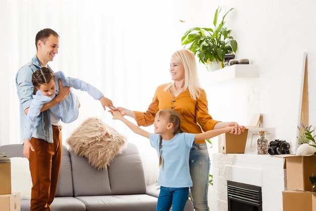 Famiglia felice che si trasferisce a casa con scatole in giro