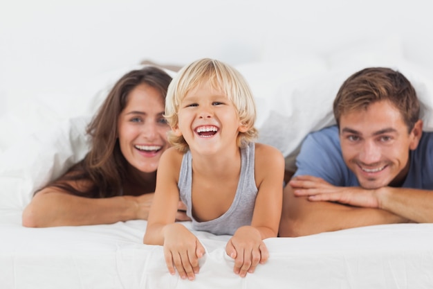 Famiglia felice che si trova insieme su un letto