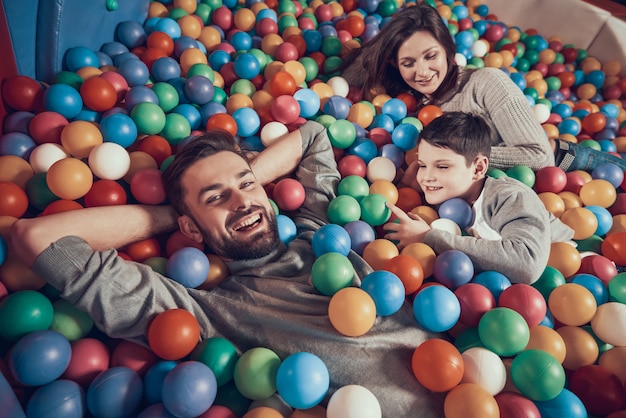 Famiglia felice che si trova nello stagno con le palle in centro commerciale.