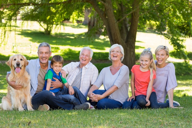 Famiglia felice che sorride alla macchina fotografica con il loro cane