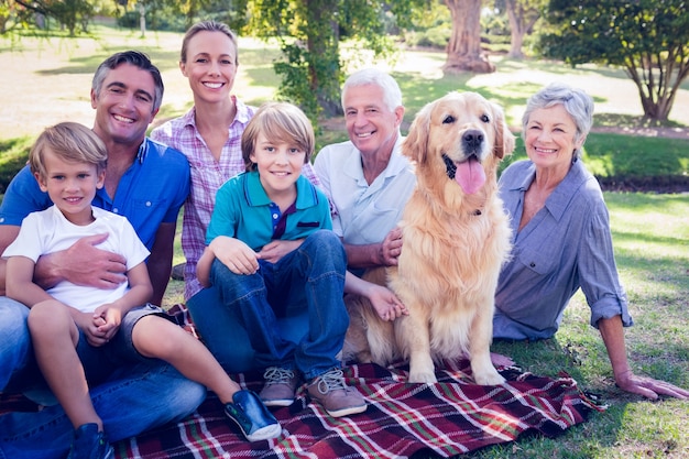 Famiglia felice che sorride alla macchina fotografica con il loro cane