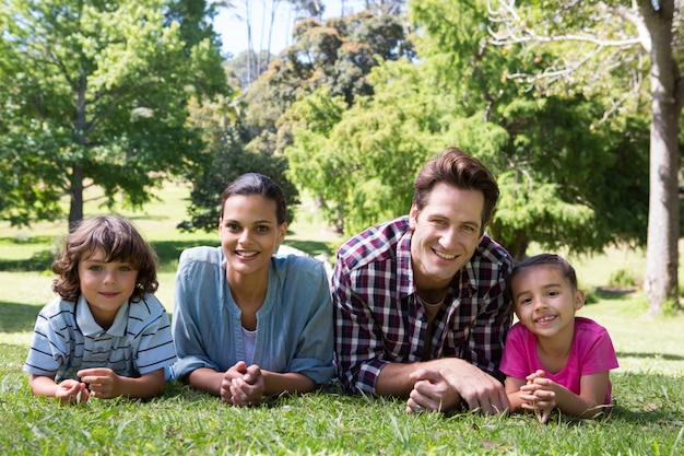 Famiglia felice che sorride alla macchina fotografica in una giornata di sole